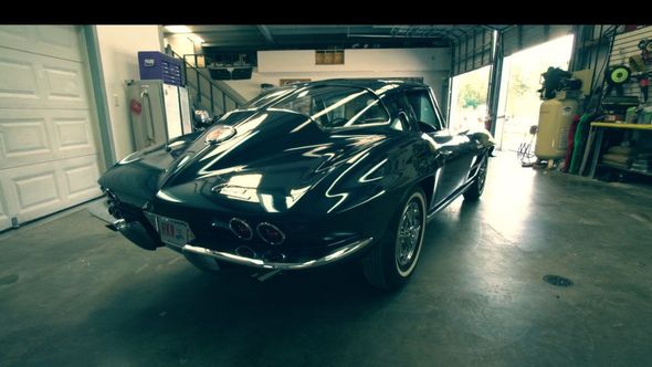 Black classic Corvette in a garage.