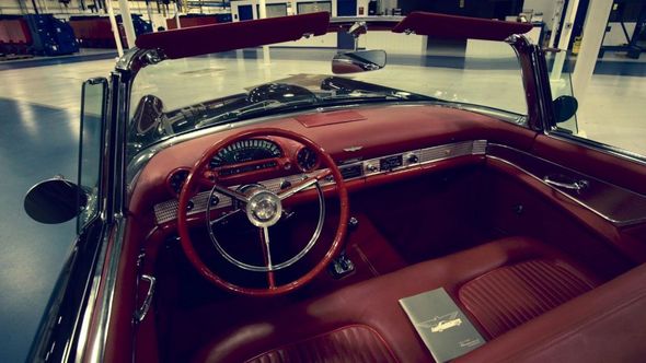 Inside view of a classic red convertible car with red interior and dashboard.