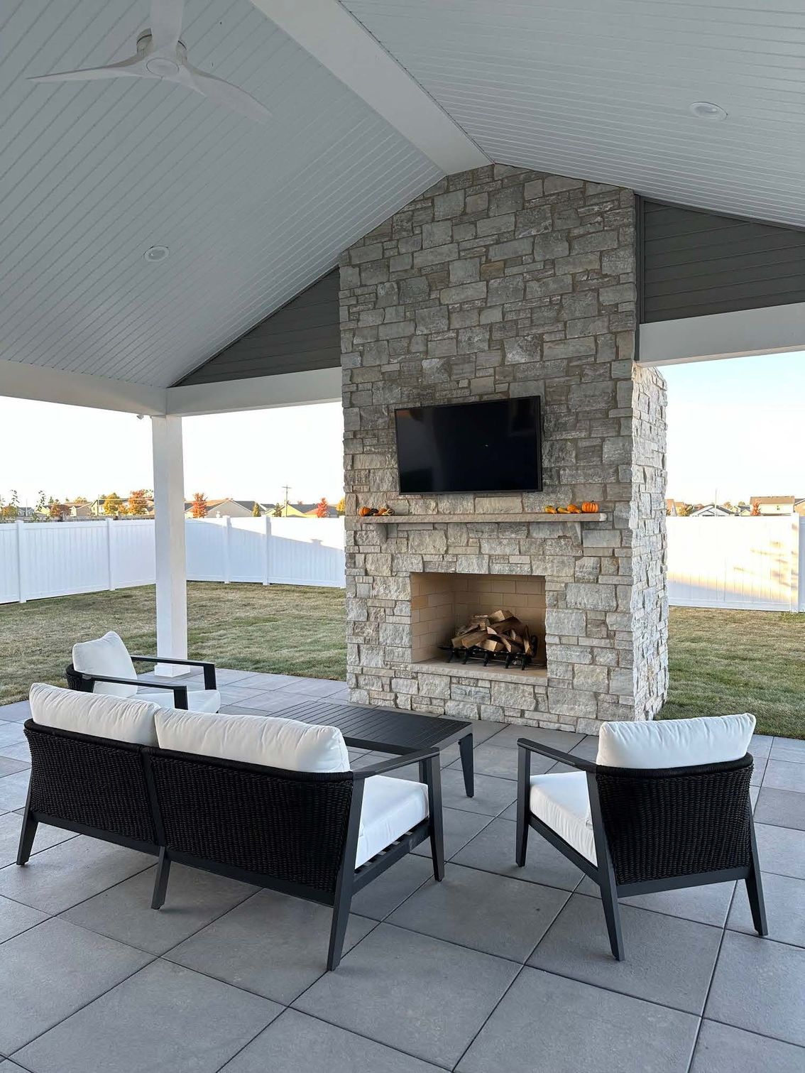 A patio with a fireplace and a flat screen tv.