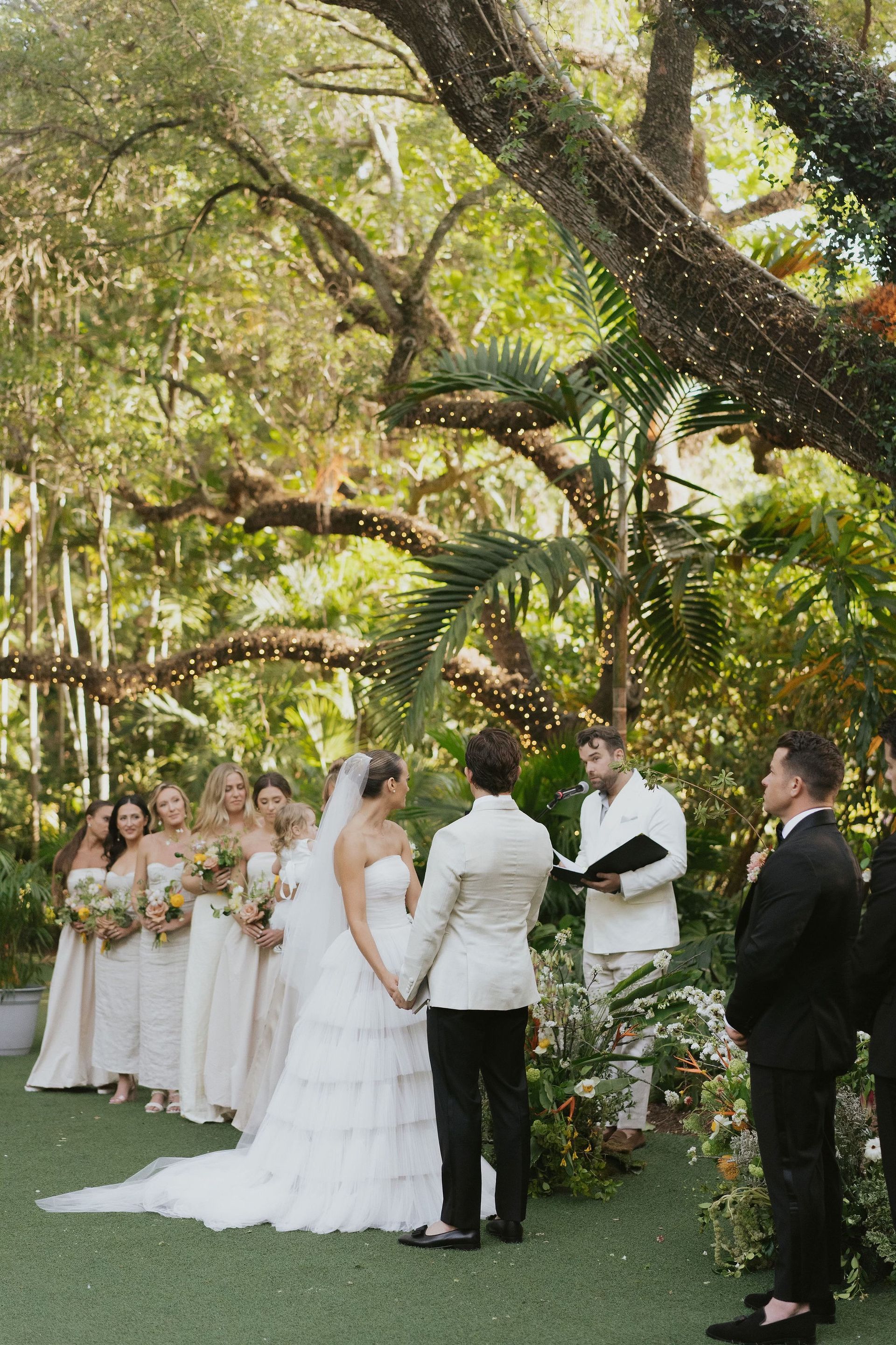 Bride and groom stand, facing each other. 