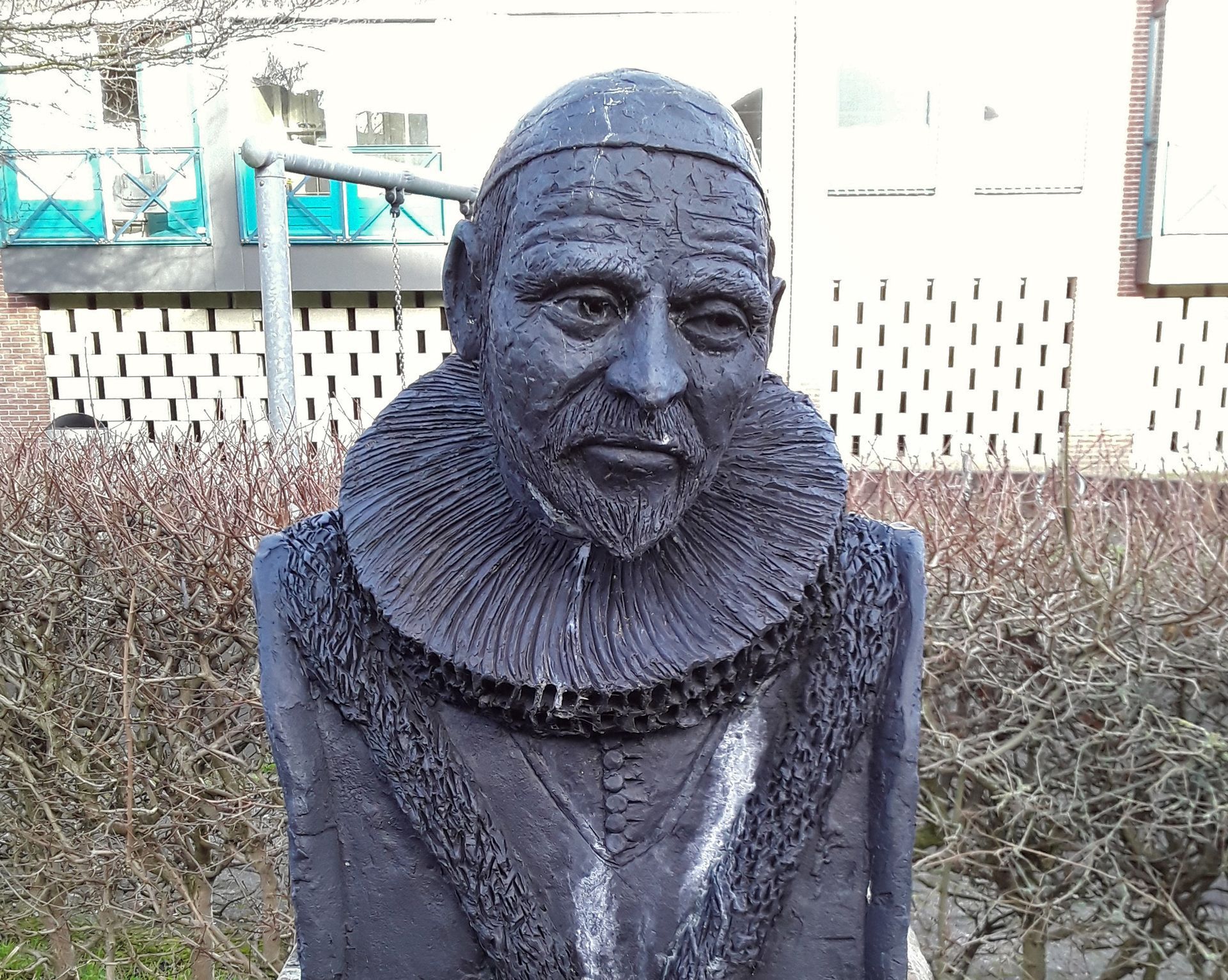 Een standbeeld van een man met een kraag en hoed