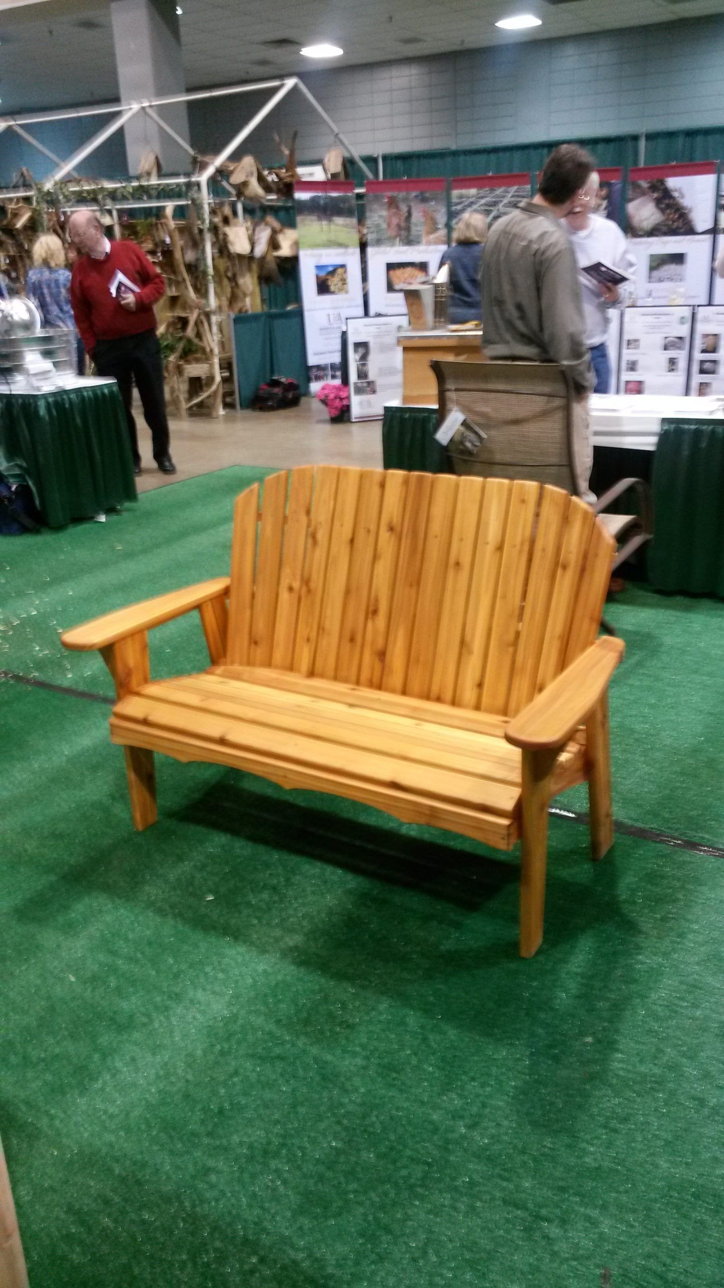 A wooden bench is sitting on top of a lush green field.