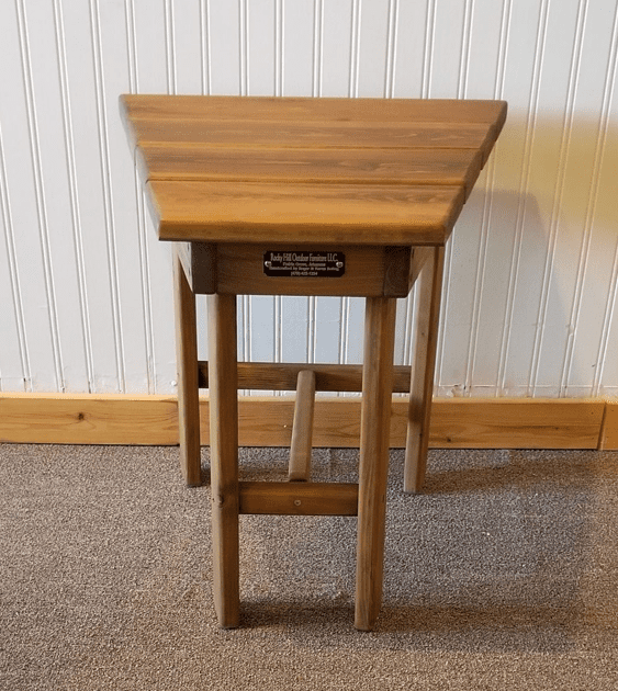 A small wooden table with a small drawer underneath it