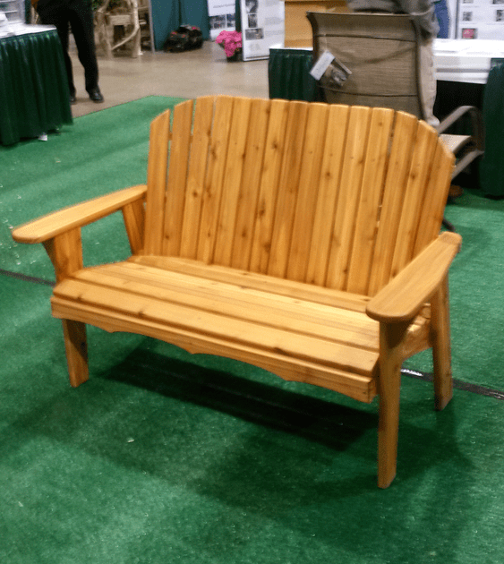 A wooden bench is sitting on a green carpet