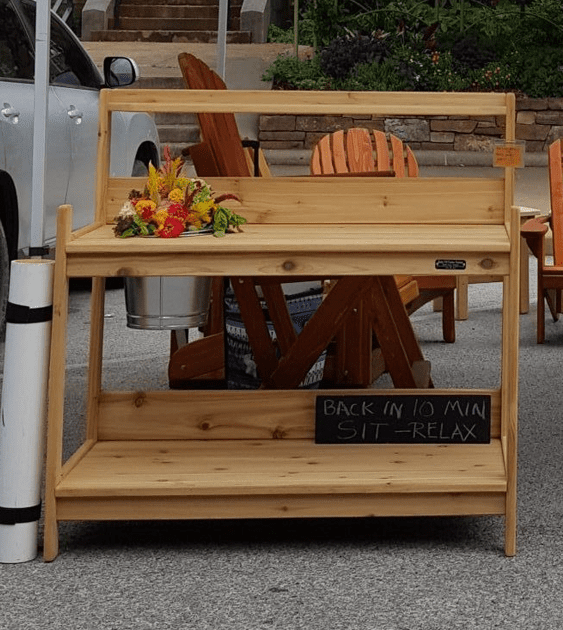 A wooden bench with a sign that says back in 15 min sit relax