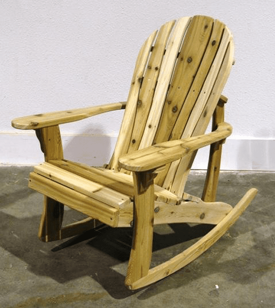 A wooden rocking chair is sitting on a concrete floor