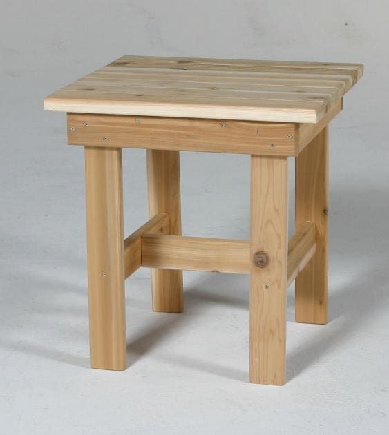 A small wooden stool is sitting on a white surface