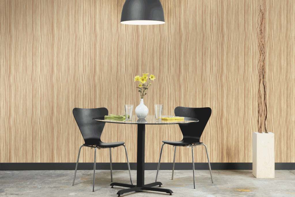 A dining room table with two chairs and a vase of flowers on it.