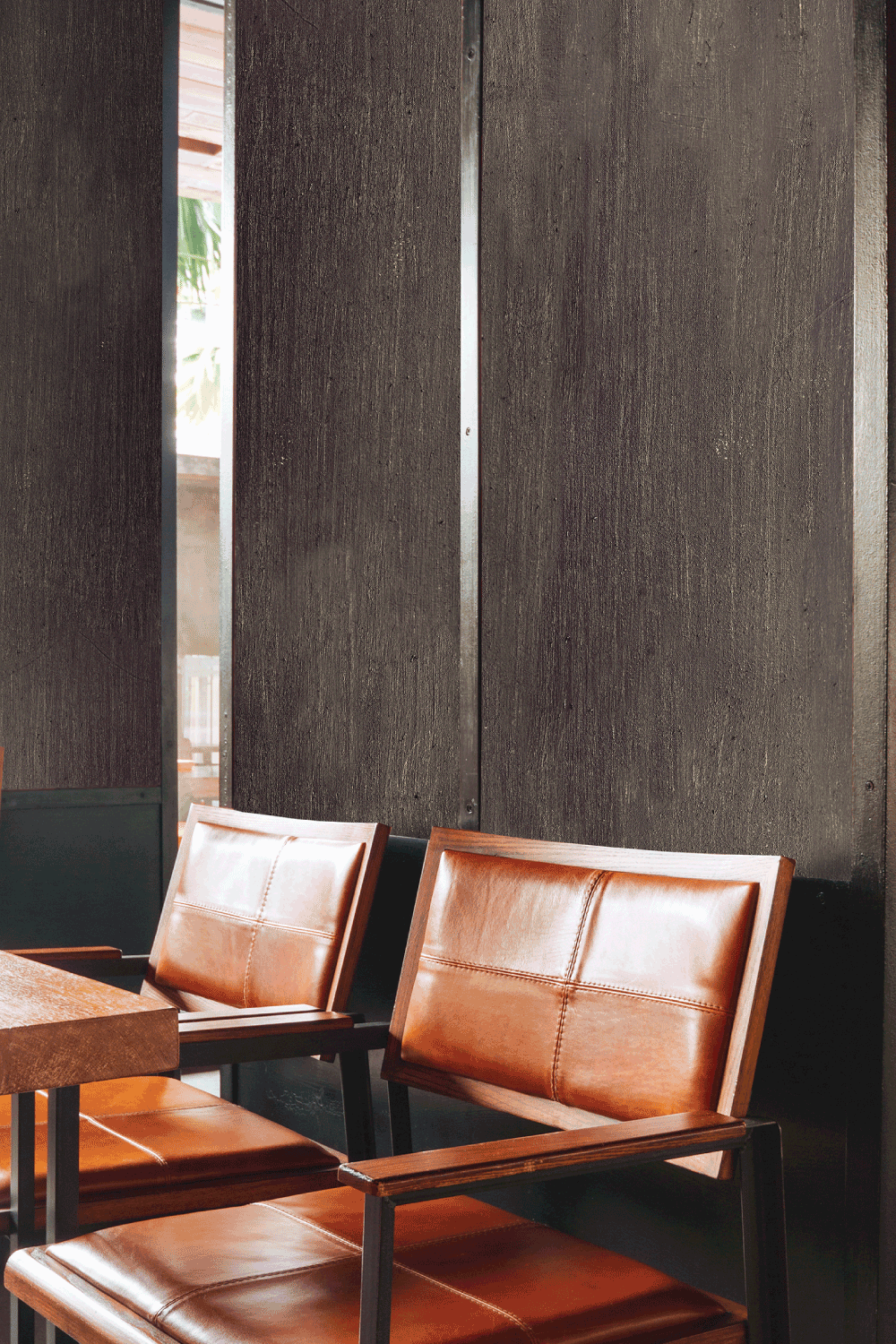 A row of brown leather chairs and a table in a room.