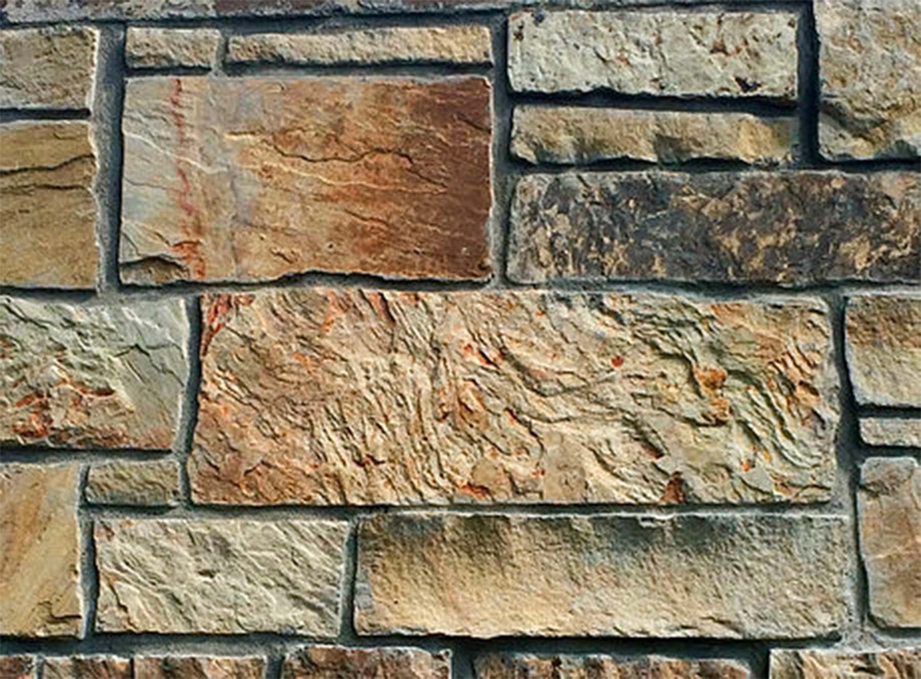A close up of a stone wall with a brick pattern