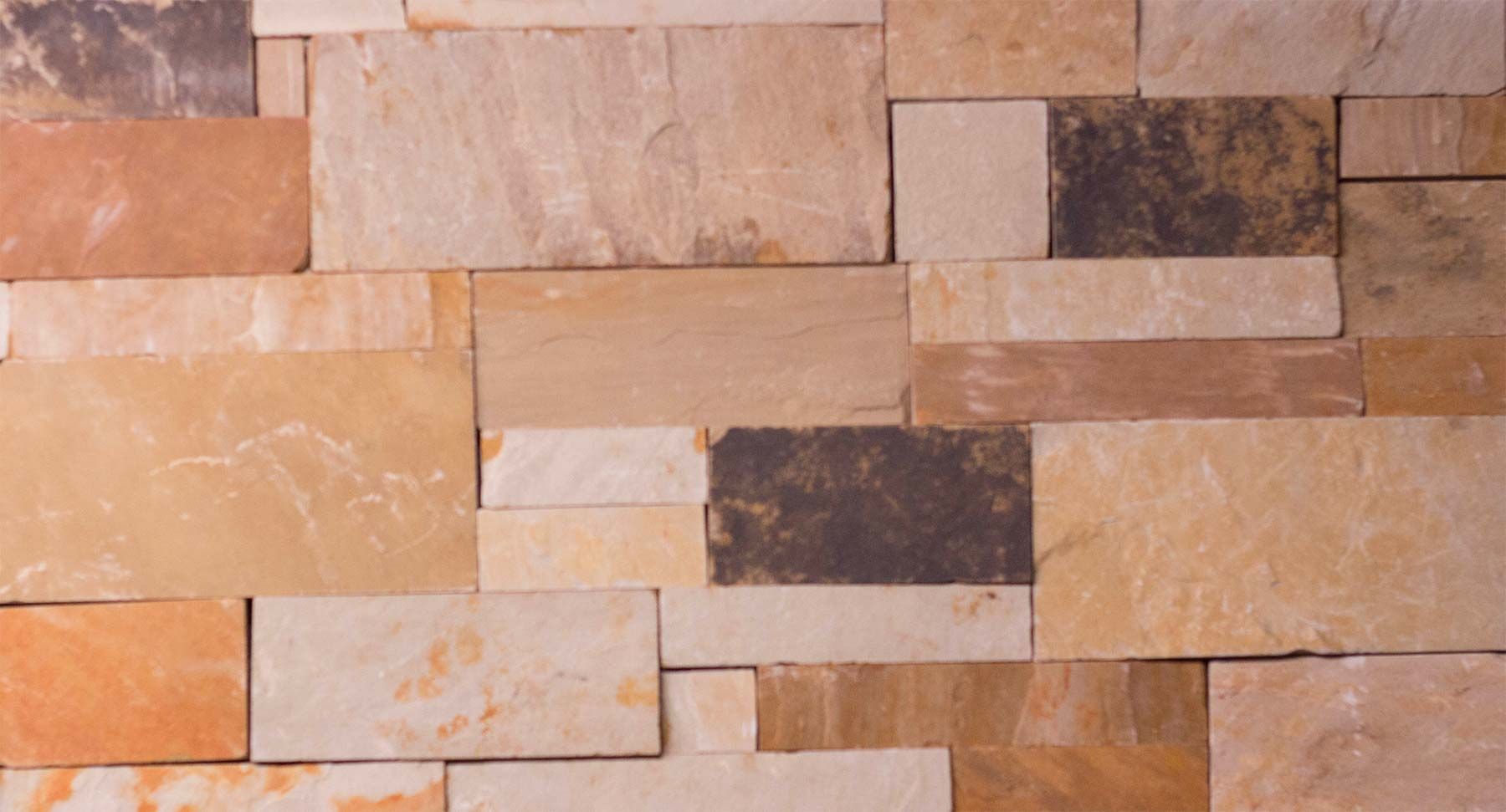 A close up of a brick wall made of different colored bricks.