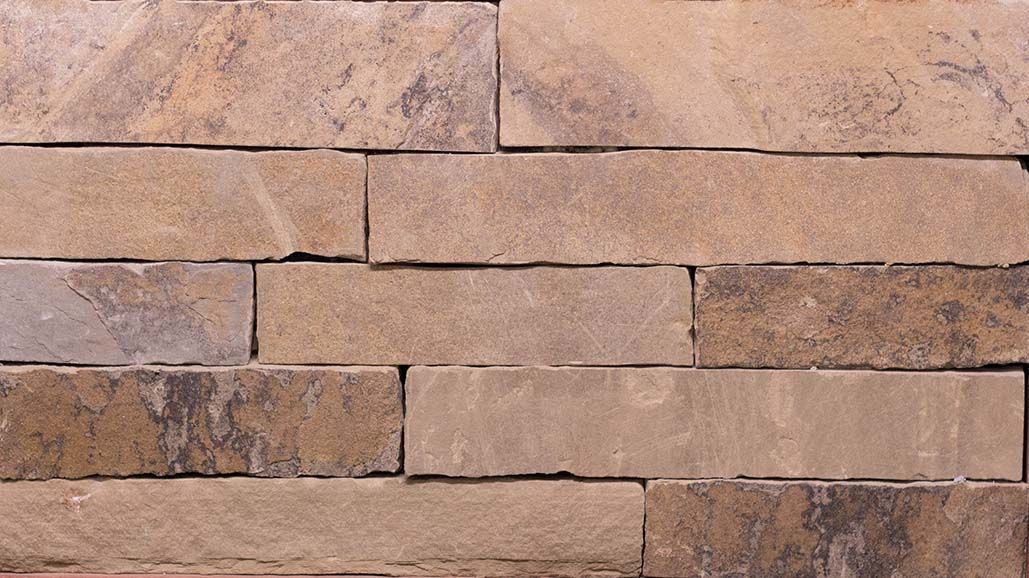 A close up of a brick wall with a few bricks missing.