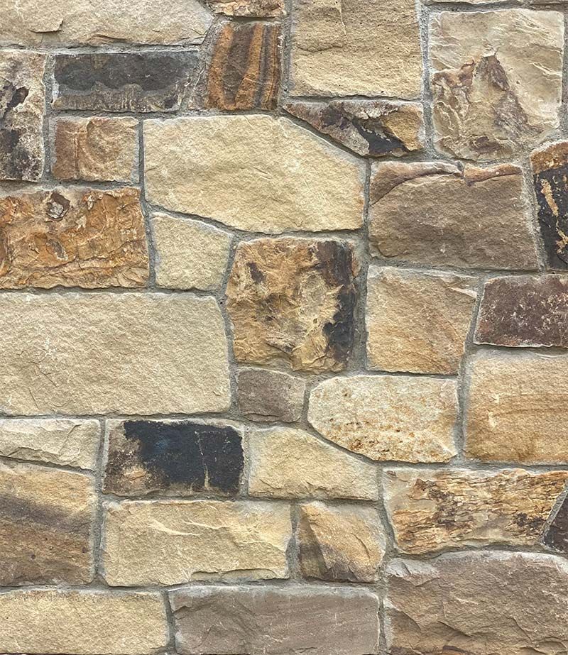 A close up of a stone wall with a lot of different types of rocks.
