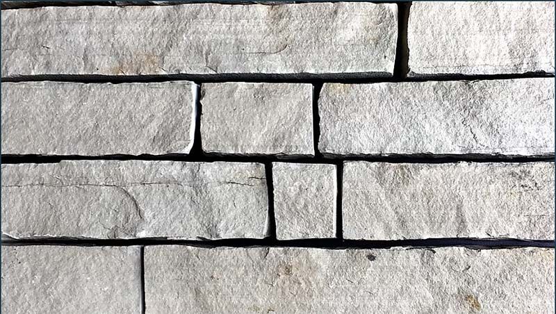 A close up of a white brick wall with a black border.