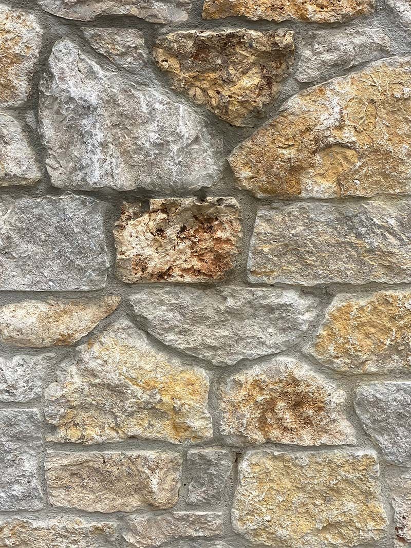 A close up of a stone wall with a lot of different types of rocks.