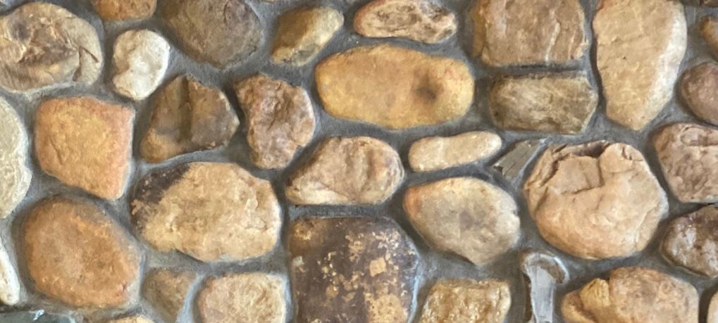 A close up of a stone wall with a lot of rocks on it.