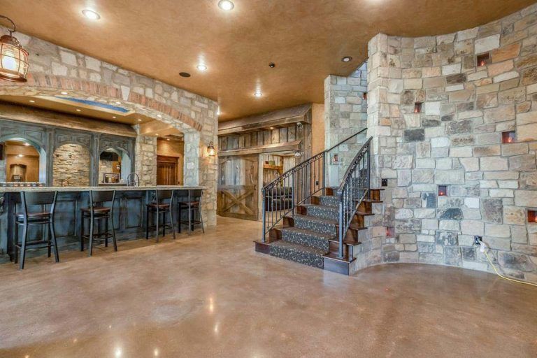 A large room with a bar and stairs in it.