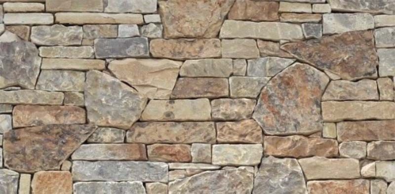A close up of a stone wall made of different types of rocks.