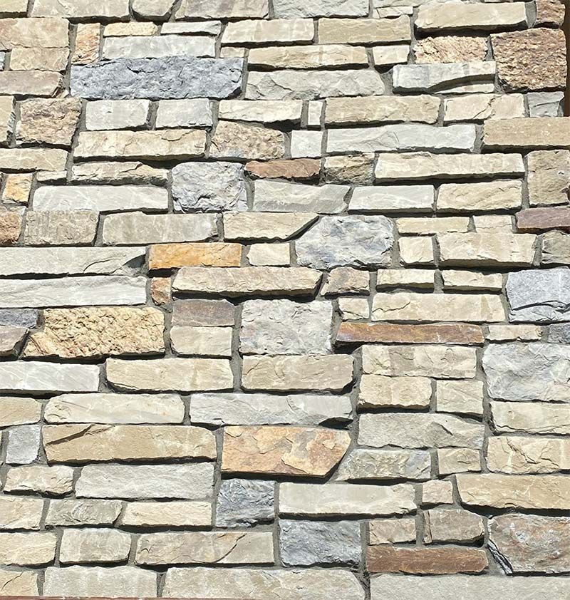 A close up of a stone wall with a brick pattern