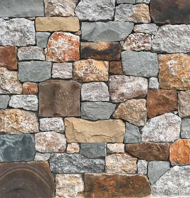 A close up of a stone wall made of different colored rocks