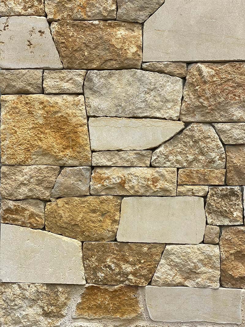 A close up of a stone wall made of different types of rocks.