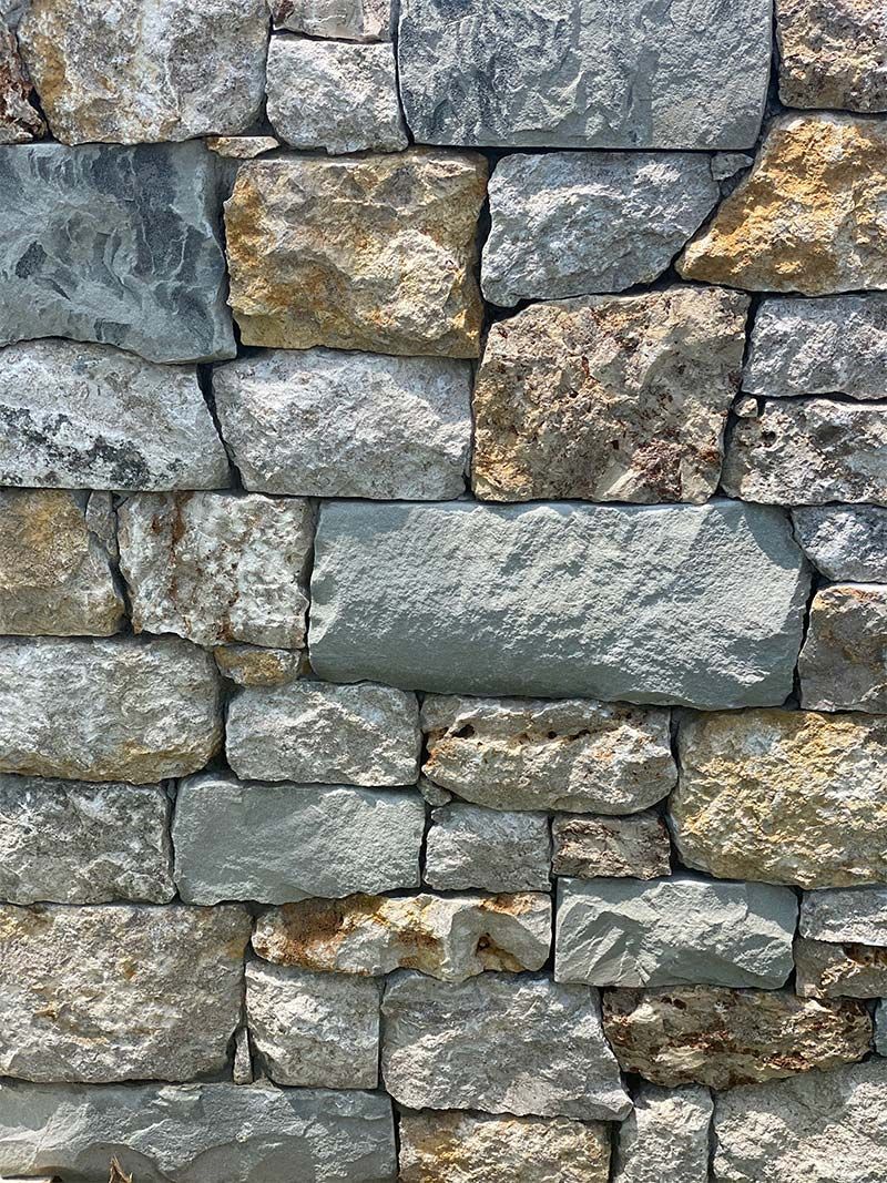 A close up of a stone wall made of different types of rocks.