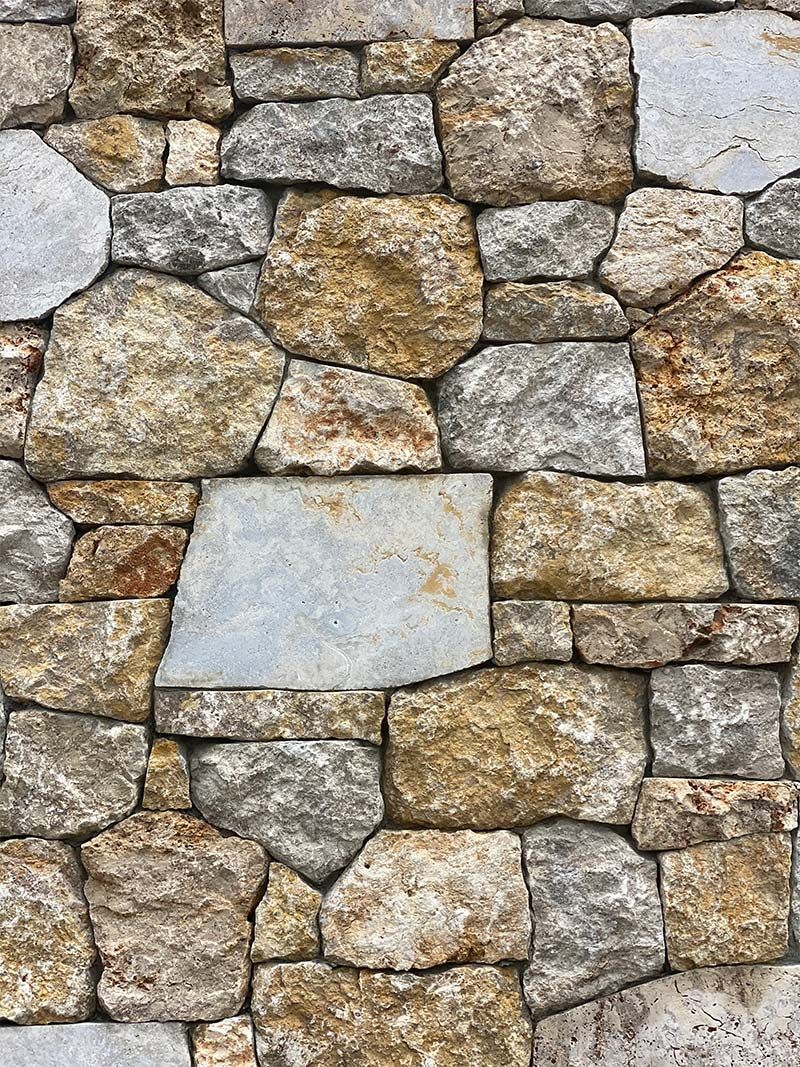 A close up of a stone wall made of different types of rocks.