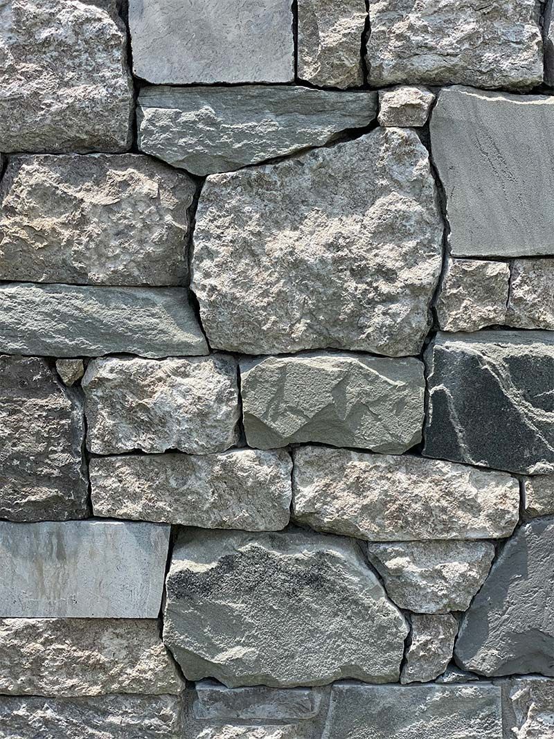 A close up of a stone wall made of different types of rocks.