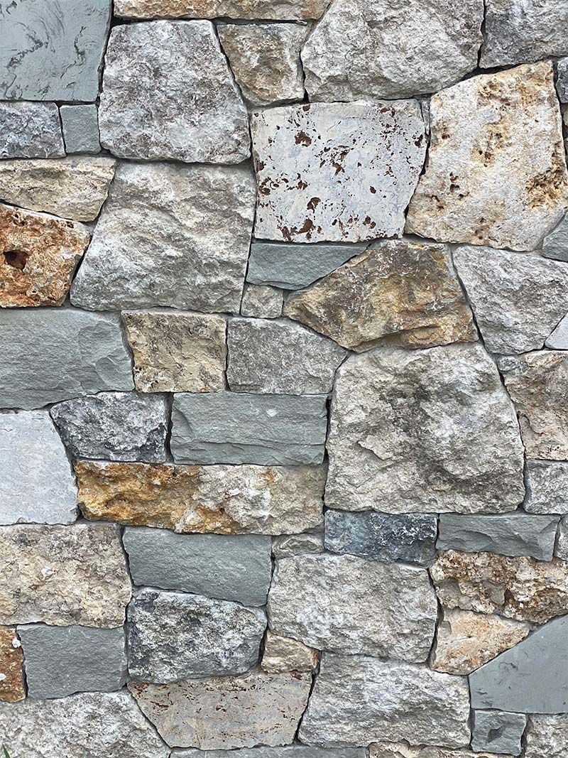A close up of a stone wall made of different types of rocks.