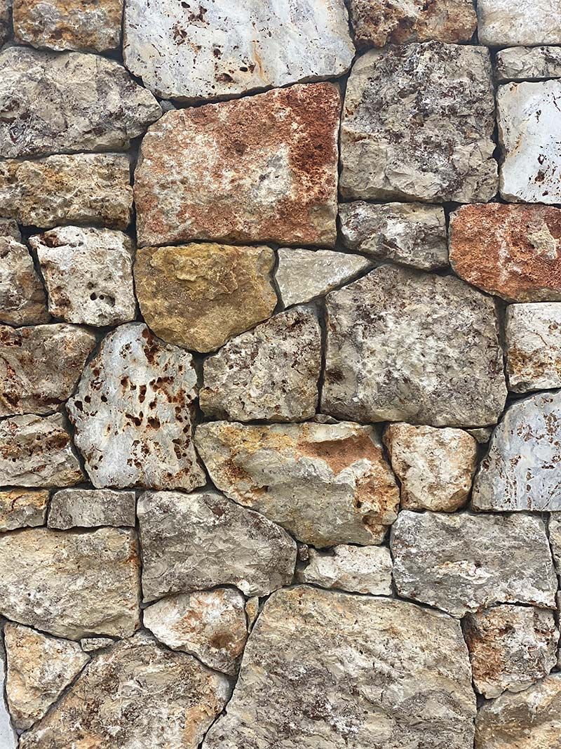 A close up of a stone wall made of different types of rocks.