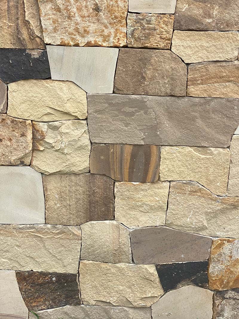 A close up of a stone wall made of different types of rocks.