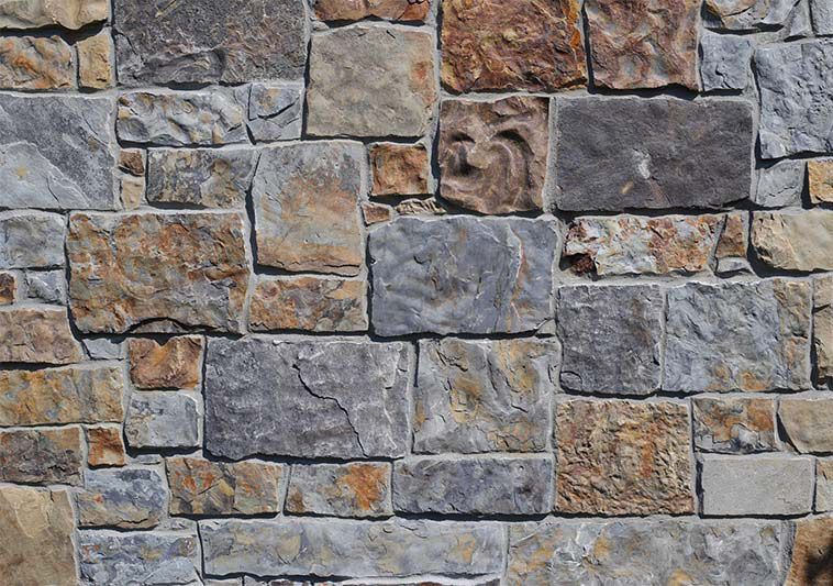 A close up of a stone wall with a variety of bricks