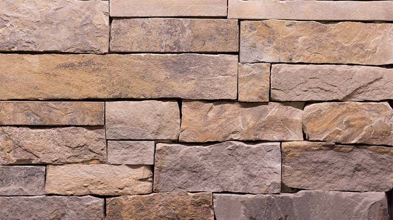 A close up of a stone wall with bricks stacked on top of each other.