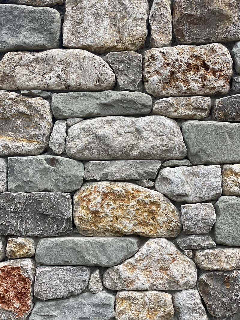 A close up of a stone wall made of different types of rocks.
