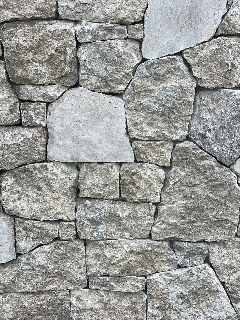 A close up of a stone wall with a lot of rocks.