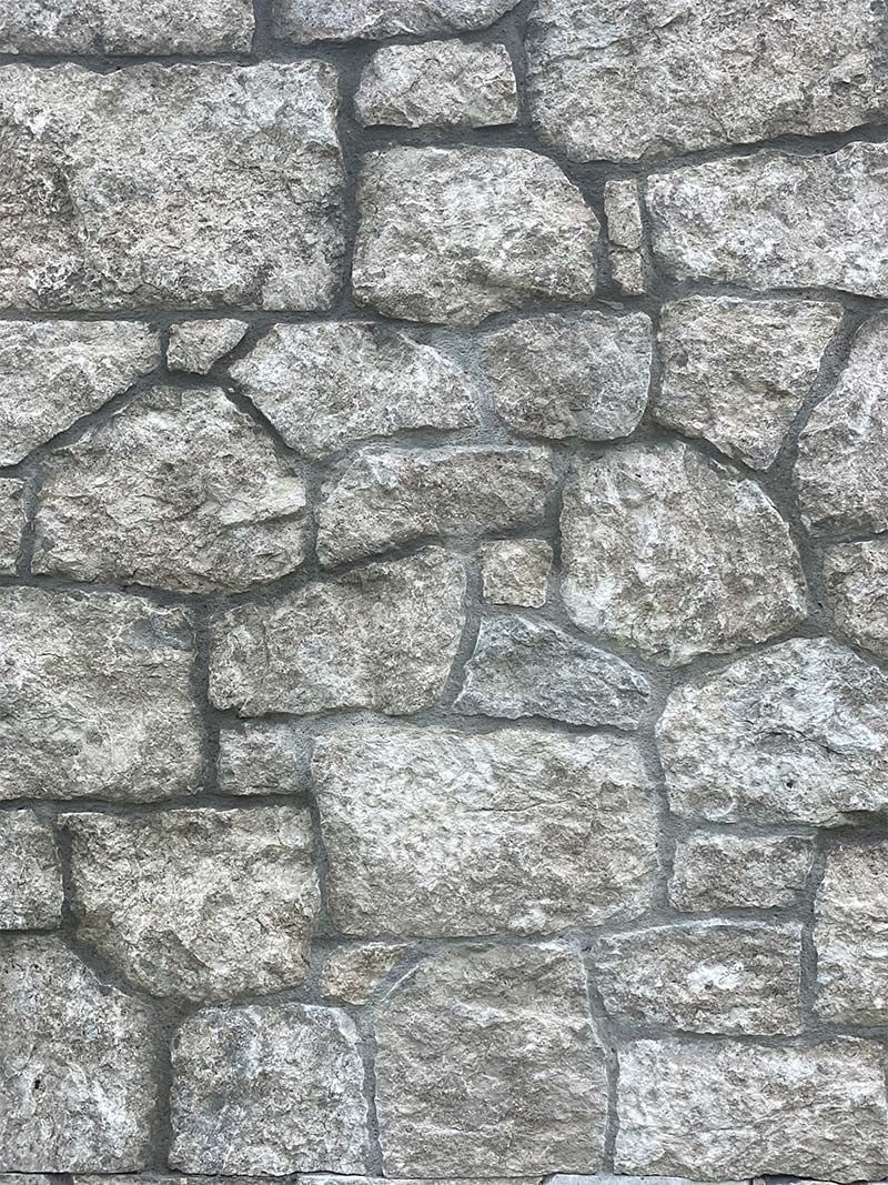 A close up of a stone wall with a lot of rocks.