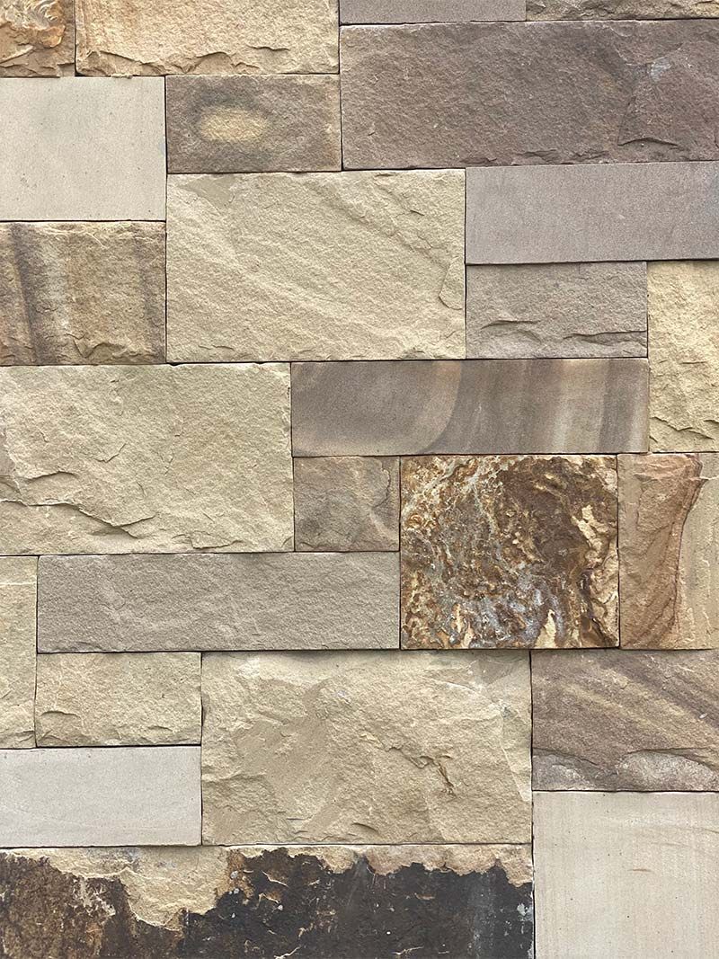 A close up of a brick wall made of different types of stone.