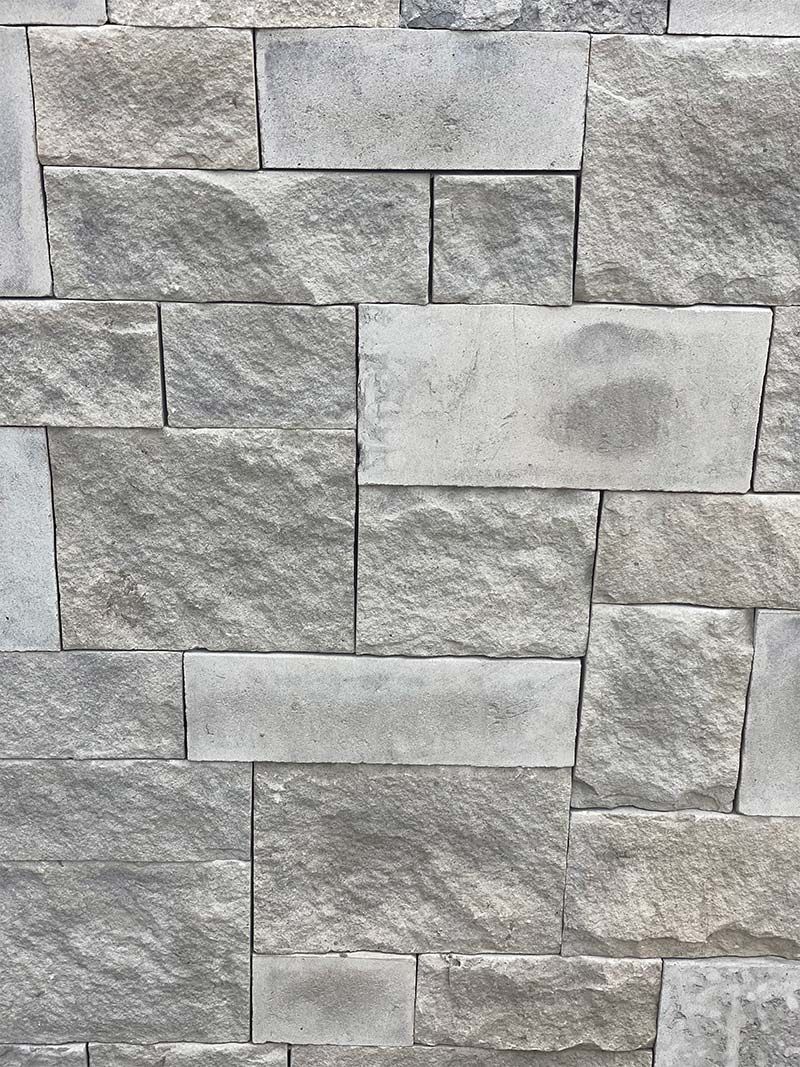 A close up of a stone wall with bricks stacked on top of each other.