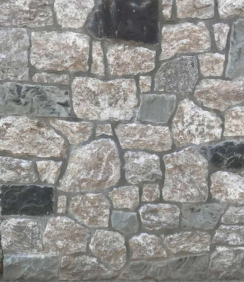 A stone wall with a lot of different types of rocks