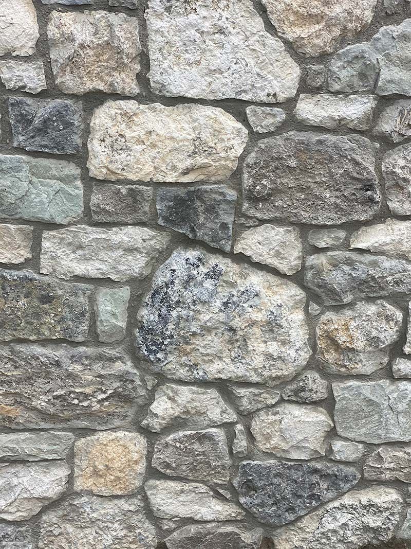A close up of a stone wall with a lot of rocks.