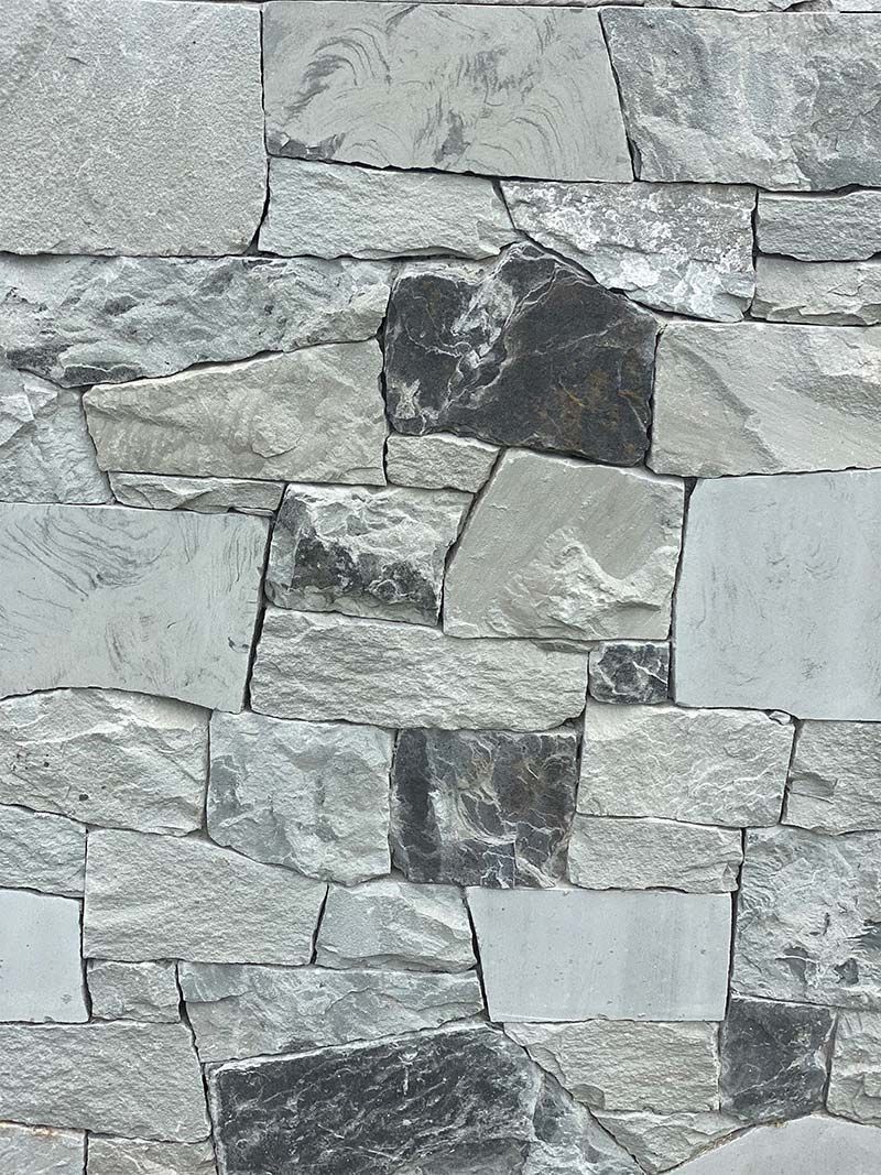 A close up of a stone wall with a lot of different types of rocks.