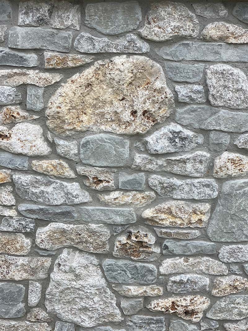 A close up of a stone wall with a lot of rocks.