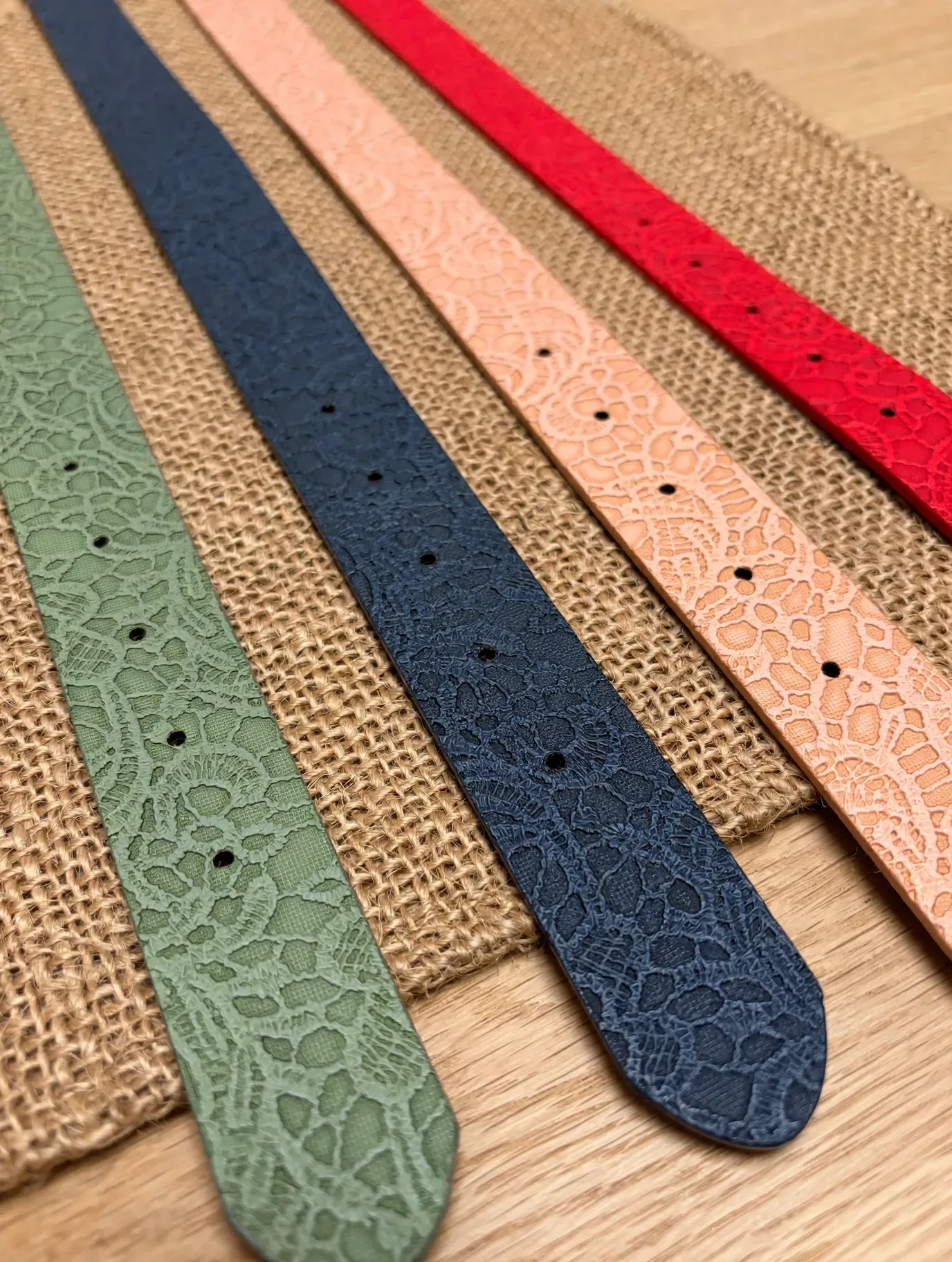 Cuatro estrechas cintas texturizadas en verde, azul, rosa y rojo dispuestas verticalmente