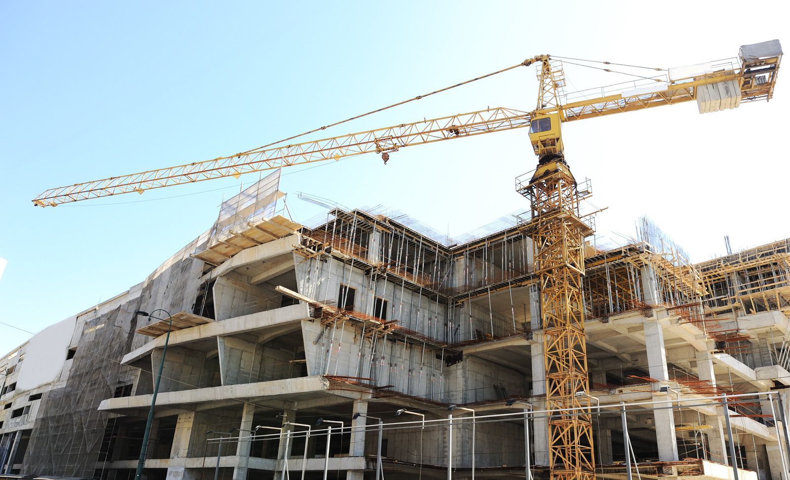 A large building is being built with a crane in the foreground.