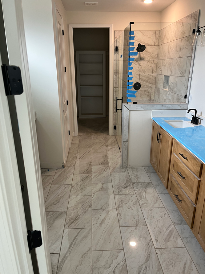 A bathroom with a blue counter top and a walk in shower.