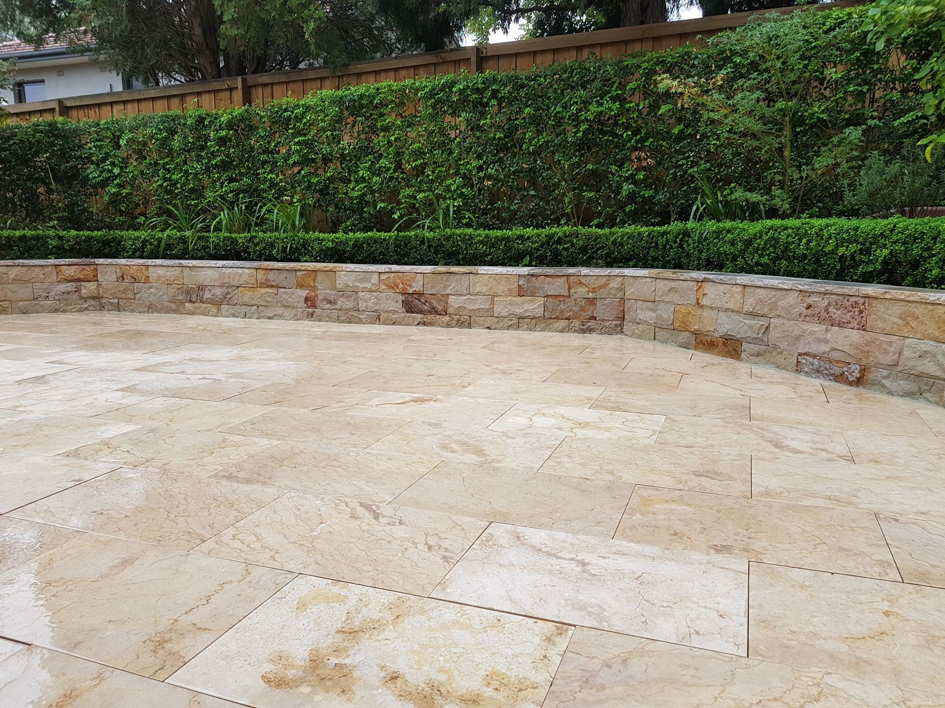 Stone Patio With Stone Wall and Green Hedge — Total Perfection In Kariong, NSW