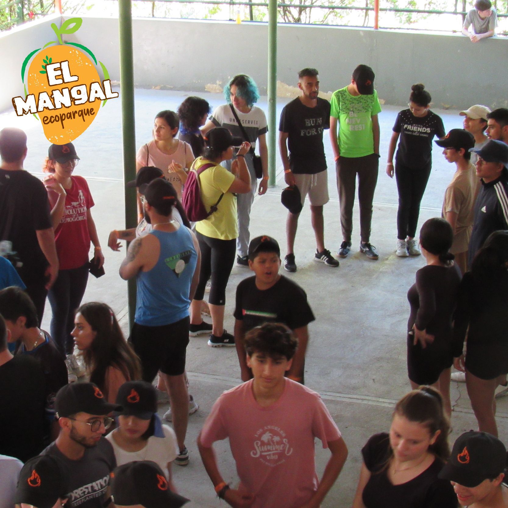 Un grupo de personas se reunió bajo una estructura blanca. Algunas llevaban sombreros y conversaban de pie.