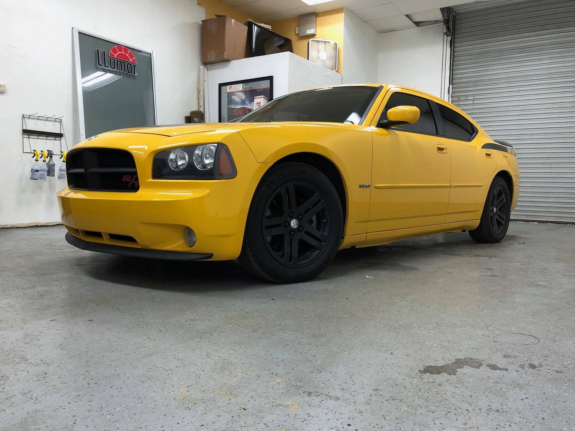 Yellow Dodge Charger parked in a garage with black wheels and tinted windows