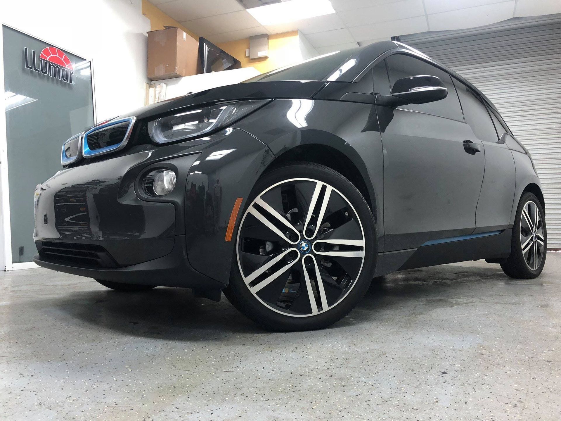 Black BMW sedan in a showroom, viewed from the front-left angle.