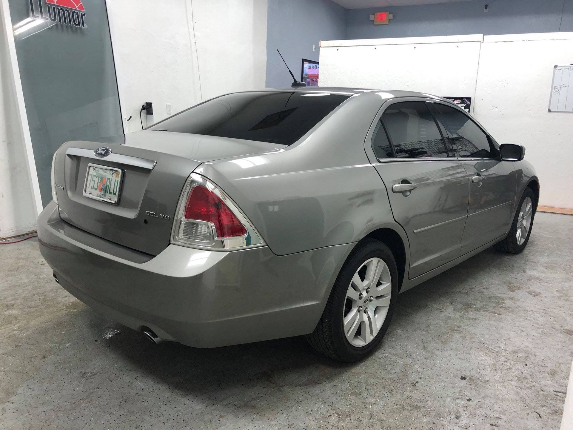 Silver sedan parked inside a garage with a white door and red wall accents